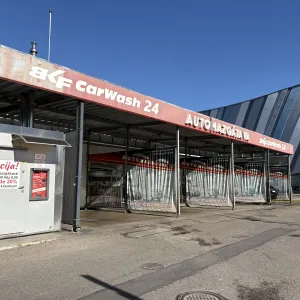 Automa&scaron;īnu mazgātava ar sarkanu uzrakstu un metāla konstrukcijām.