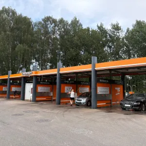 Āra automazgātava ar vairākiem mazgā&scaron;anas boksiem oranžā krāsā.