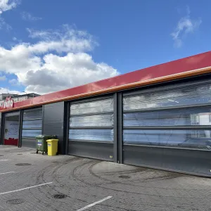 Automa&scaron;īnu mazgātava ar vairākām iebrauktuvēm, zilas debesis fonā.