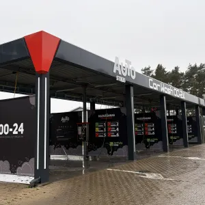 Tum&scaron;a automazgātava ar norādēm, pelēkas debesis.