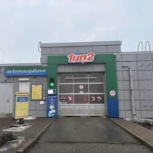 Automazgātuves ēka ar durvīm un zīmēm pie ieejas.