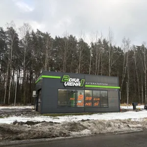 Pelēka automazgātava meža malā, ziemas ainava.