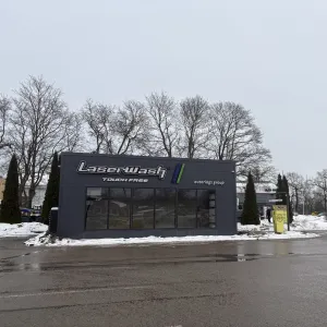 Automazgātava ziemas laikā, pelēcīga debess un sniegotas malas.