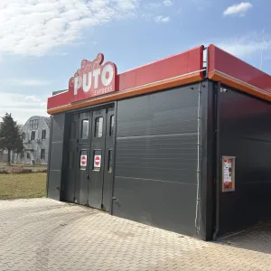 PUTO express portāla automazgātava Daugavas ielā 28, Mārupē &ndash; melna ēka ar sarkanu jumta malu un PUTO logo