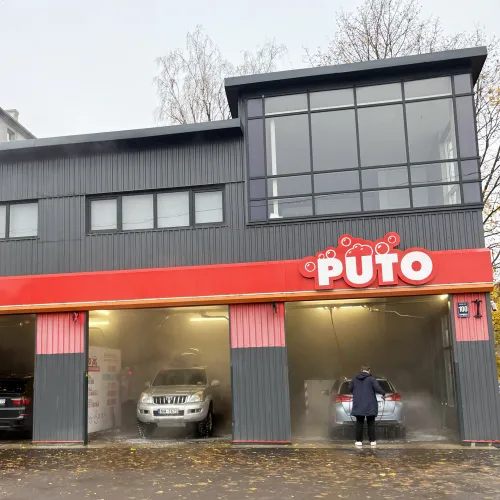 Automazgātava ar vairākiem vārtiem zem mākoņainām debesīm.