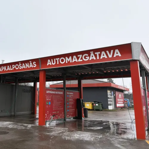 Automazgātava ar sarkaniem akcentiem un uzrakstiem.