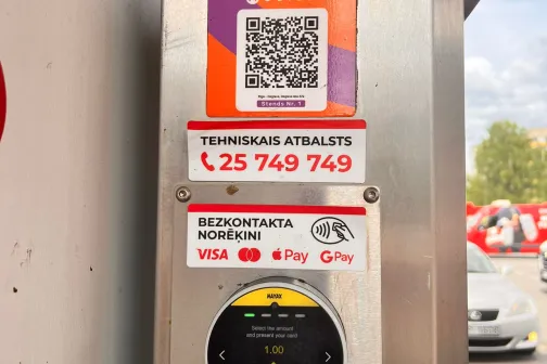 Metāla maksājumu terminālis ar QR kodu un uzlīmēm.