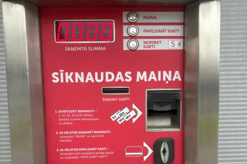 Automāta panelis ar monētu maiņas funkciju, sarkanā krāsā, auto mazgātavā.