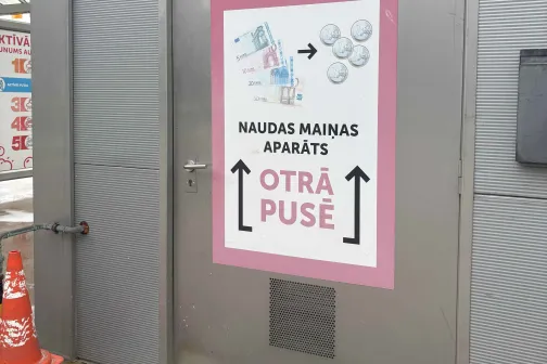 Pelēkas durvis ar zīmi par norādēm, autostāvvietas fons.