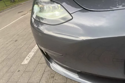 Pelēka automa&scaron;īnas priek&scaron;daļa stāvvietā.