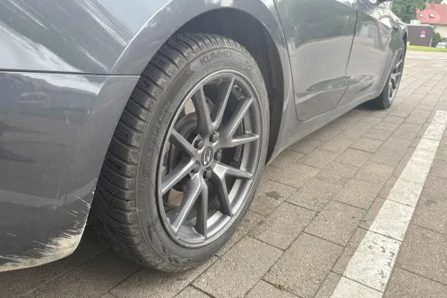 Pelēkas automa&scaron;īnas sānskats uz bruģētas ielas.