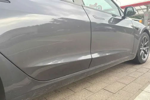 Pelēka automa&scaron;īna tuvplānā stāvvietā.