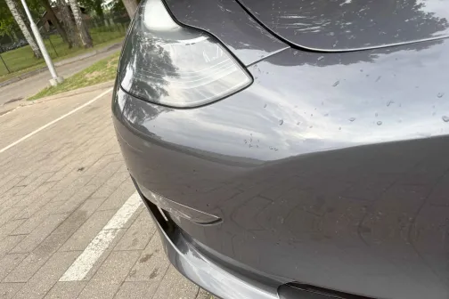 Pelēka automa&scaron;īna stāvvietā, uz tās ir ūdens pilieni.