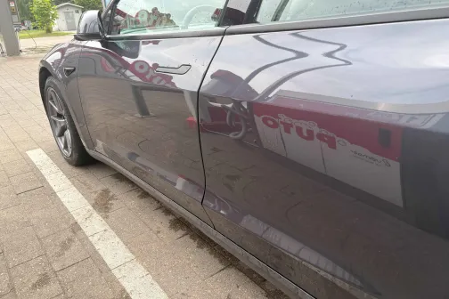 Melnas automa&scaron;īnas sāns tīrā stāvlaukumā.