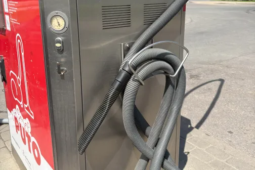 Putekļusūcējs pie automazgātuves skaidrā dienas gaismā.