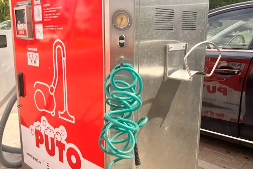 Putekļsūcēja automatizētā iekārta ar sarkanu dizainu un zilu cauruli.