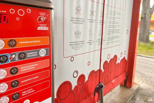 Sarkanbaltā automazgātuves interjera skats ar mazgā&scaron;anas instrukcijām.