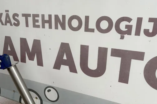 Sienas grafika ar uzrakstu pie automazgātuves.