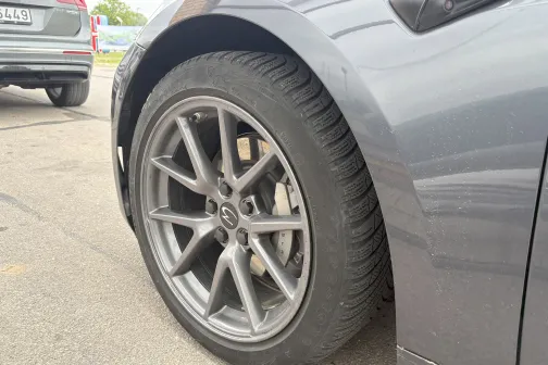 Pelēka automa&scaron;īna uz ielas, redzams priek&scaron;ējais ritenis.