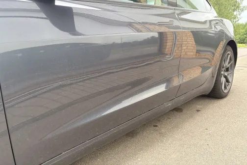 Metāliski pelēkas automa&scaron;īnas sāns ar atspīdumiem.