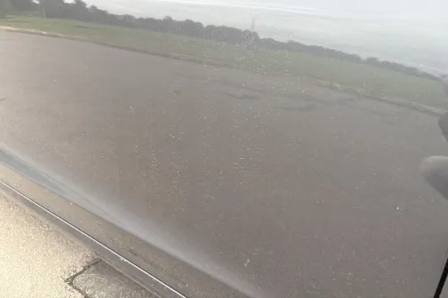 Spoguļgluda automa&scaron;īnas virsma, atspoguļo ceļu un debesis.