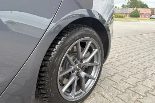 Mitrs automa&scaron;īnas ritenis uz bruģa pie autostāvvietas.