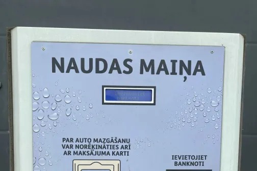 Naudas maiņas automāts ar pogām un monētu iemeti.