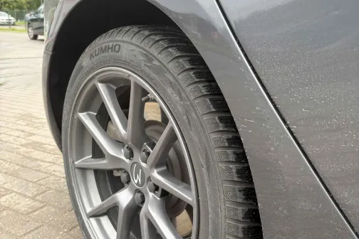 Auto aizmugurējais ritenis uz bruģēta ceļa.