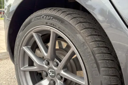 Auto aizmugurējais ritenis ar sudrabainiem diskiem.