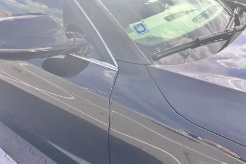 Spīdīga, melna automa&scaron;īna zemē klajā dienā.