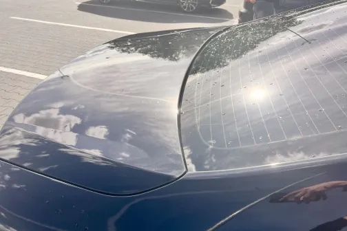 Spīdīga automa&scaron;īnas aizmugure ar saules atspīdumu.