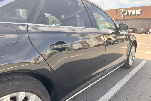 Melnas automa&scaron;īnas sānskats stāvvietā pie veikala.