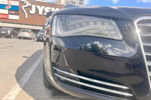 Melnas automa&scaron;īnas priek&scaron;puse ar atspīdumiem.