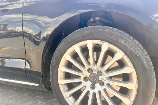 Melnas automa&scaron;īnas priek&scaron;ējais ritenis uz bruģakmens.