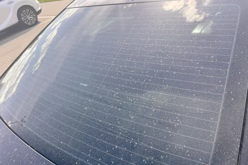 Netīrs aizmugurējais auto stikls ar ūdens traipiem.