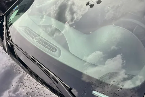 Automobiļa priek&scaron;ējais stikls ar pēdām no lietus pilieniem.