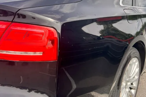 Melnas automa&scaron;īnas aizmugure saulainā dienā pēc mazgā&scaron;anas.