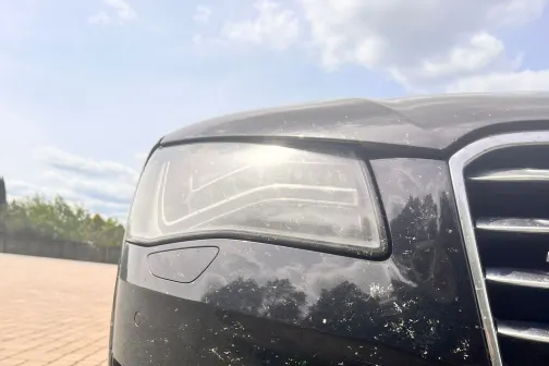 Melns auto priek&scaron;puse ar dubļainu buferi uz klona fona.