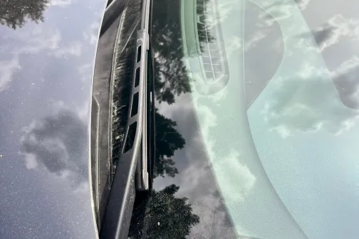 Automa&scaron;īnas priek&scaron;ējais stikls ar atspulgotajiem mākoņiem.