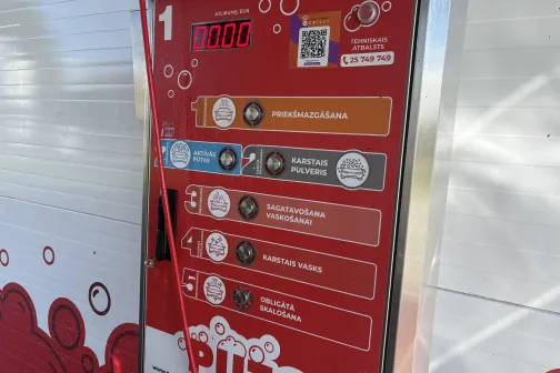 Sarkans automazgātuves vadības panelis ar pakalpojumu izvēli.