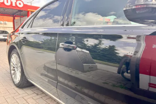 Melna automa&scaron;īna ar spīdīgām durvīm pie automazgātuves.