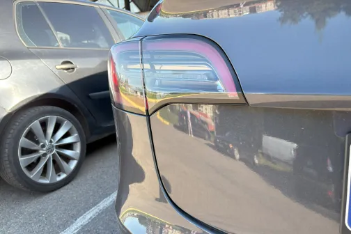 Melna automa&scaron;īna stāv blakus citai automa&scaron;īnai stāvvietā.