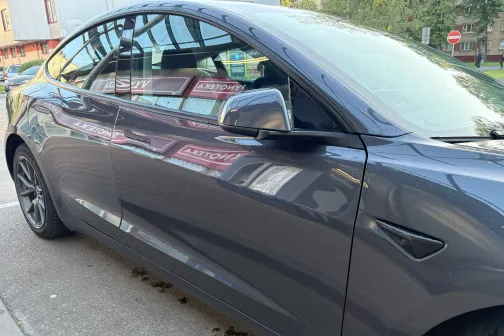 Pelēkas automa&scaron;īnas sānskats pie auto mazgātavas.