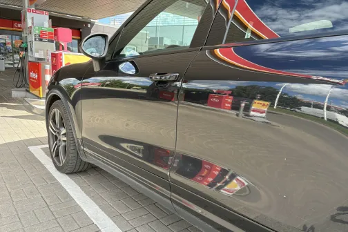 Melnas automa&scaron;īnas uzpulētas durvis pie degvielas uzpildes stacijas.