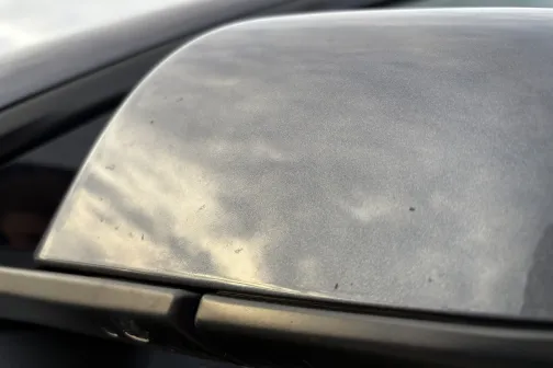 Automa&scaron;īnas sānskata spogulis ar debesu atspulgu.