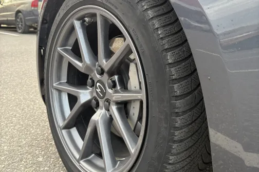 Pelēka automa&scaron;īna ar riteņa disku, skats no sāna.