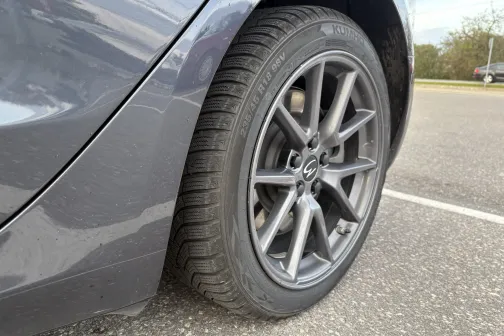 Automobiļa riepa uz asfalta stāvlaukumā.