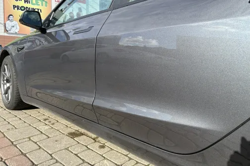 Pelēka automa&scaron;īna pie automazgātuves uz bruģēta seguma.