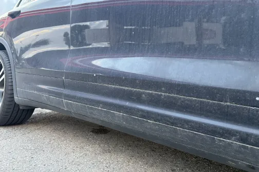 Netīra automa&scaron;īnas sāna durvis ar putekļiem un dubļiem.