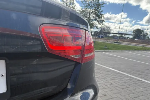 Auto stāvlaukumā, redzama aizmugures kreisā lampa.